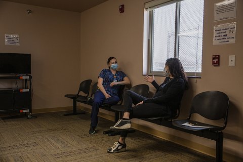 Infection control nurse Molly Longrake, left, and Vicki Hebb talk in the waiting room of the Cherry Creek clinic while Hebb waits the required 15 minutes after her Covid-19 vaccination. March 9, 2021.
