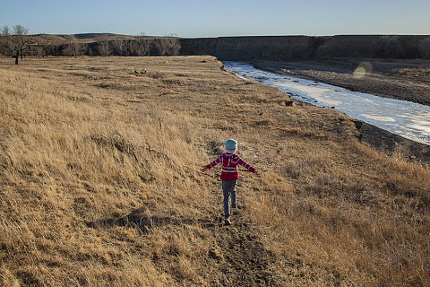 Ava Grindstone plays on her family's land along the Moreau River on the Cheyenne River Reservation, a sovereign Lakota nation in the state of South Dakota. The Moreau is a tributary of the Missouri River, which forms the reservation's eastern boundary. 